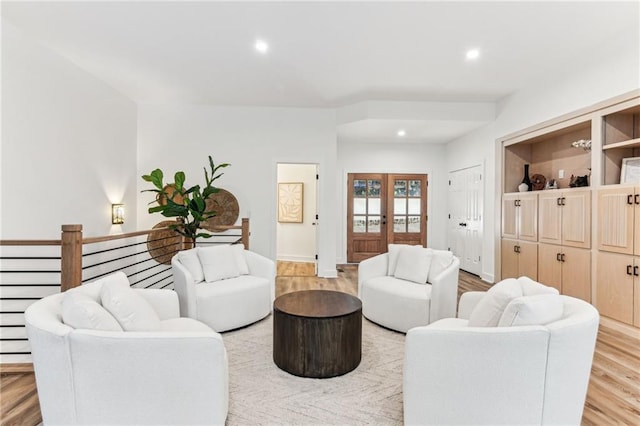 living room featuring baseboards, french doors, light wood-type flooring, and recessed lighting