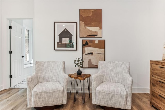 living area with baseboards and wood finished floors