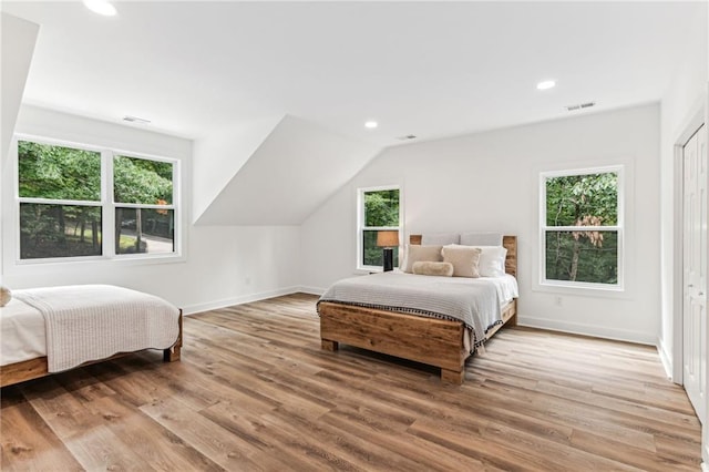 bedroom with light wood finished floors, multiple windows, and visible vents