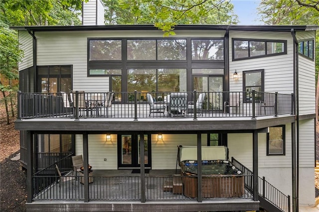 rear view of house featuring a deck, a chimney, and stairs