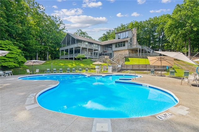 community pool with a yard and stairway