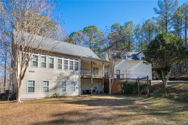 rear view of house featuring ceiling fan and a lawn