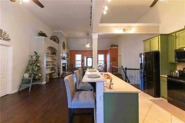 kitchen featuring black fridge with ice dispenser, green cabinets, and ceiling fan