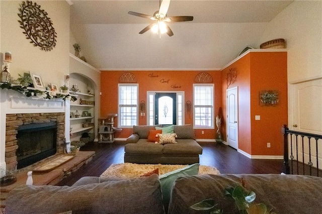 living room with a healthy amount of sunlight, vaulted ceiling, built in shelves, and a fireplace