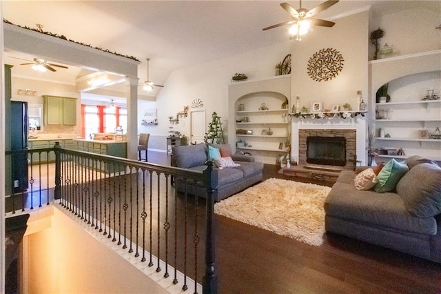 living room featuring wood-type flooring, built in shelves, ceiling fan, a fireplace, and high vaulted ceiling