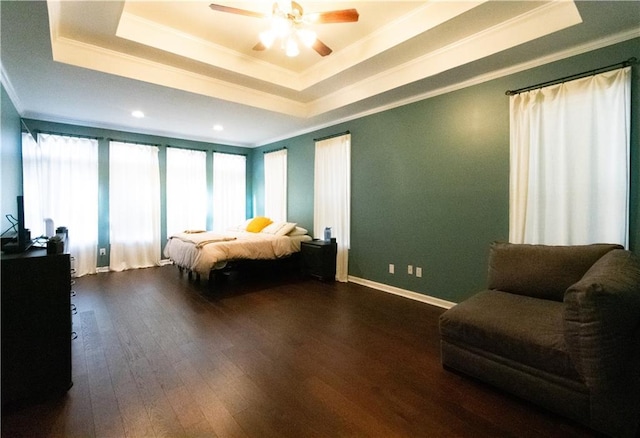 bedroom featuring a raised ceiling, crown molding, and dark wood-type flooring