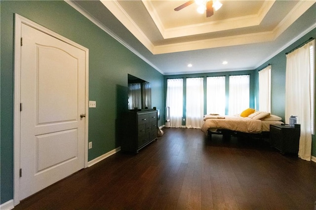 bedroom featuring ceiling fan, dark wood-type flooring, crown molding, and a raised ceiling