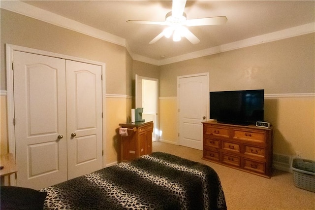 bedroom featuring a closet, ceiling fan, carpet flooring, and ornamental molding