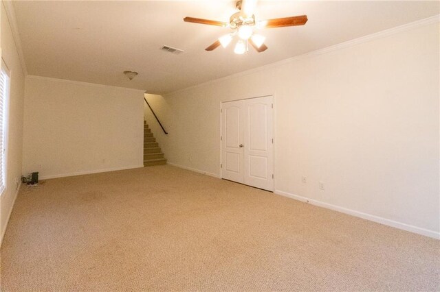 carpeted empty room with ceiling fan and ornamental molding