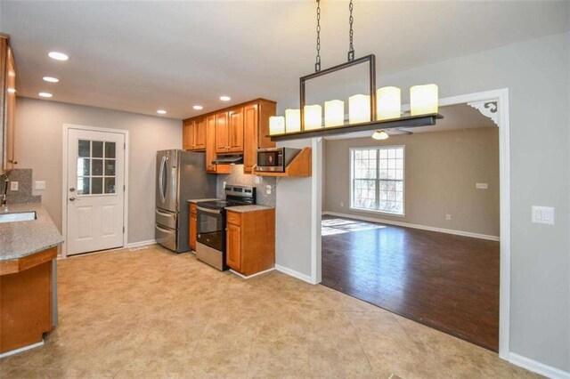 kitchen featuring hanging light fixtures, decorative backsplash, dishwasher, and sink