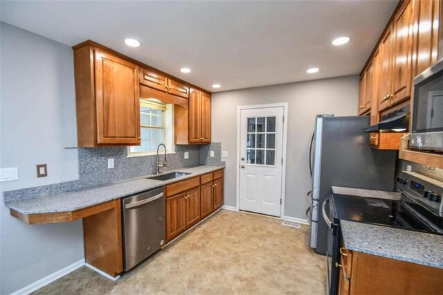 kitchen featuring light stone countertops, sink, backsplash, and appliances with stainless steel finishes