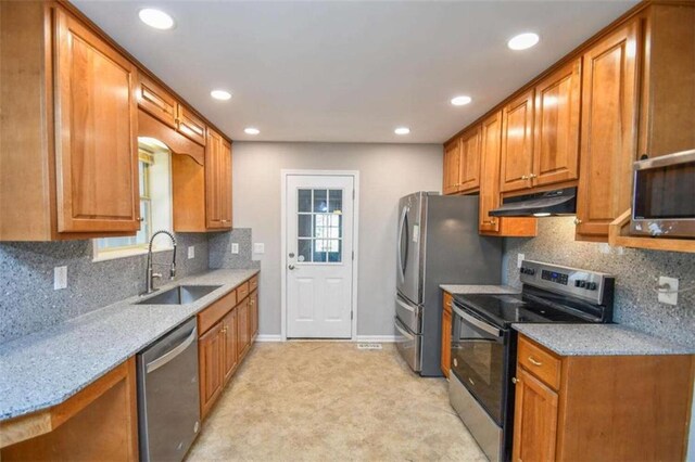 kitchen with tasteful backsplash, light stone countertops, sink, and stainless steel appliances