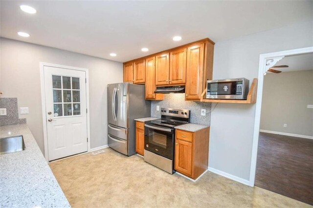 kitchen featuring decorative backsplash, dishwasher, light stone counters, and sink