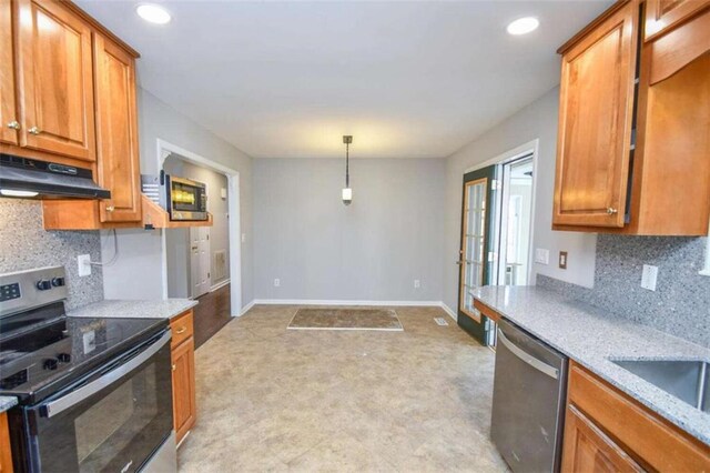 kitchen featuring stainless steel appliances, backsplash, light stone counters, and hanging light fixtures