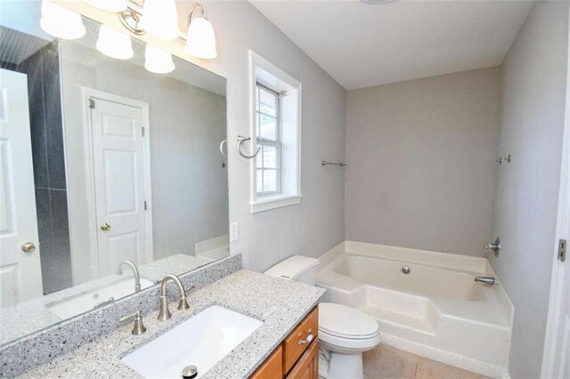 bathroom with toilet, a tub to relax in, and vanity