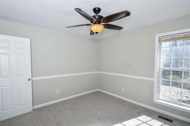 spare room featuring ceiling fan and light carpet