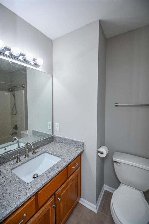 full bathroom featuring toilet, vanity, and  shower combination