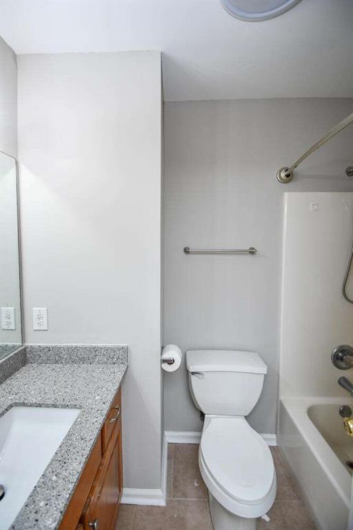 full bathroom featuring toilet, vanity, and bathtub / shower combination