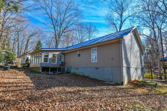 view of home's exterior with cooling unit and a sunroom