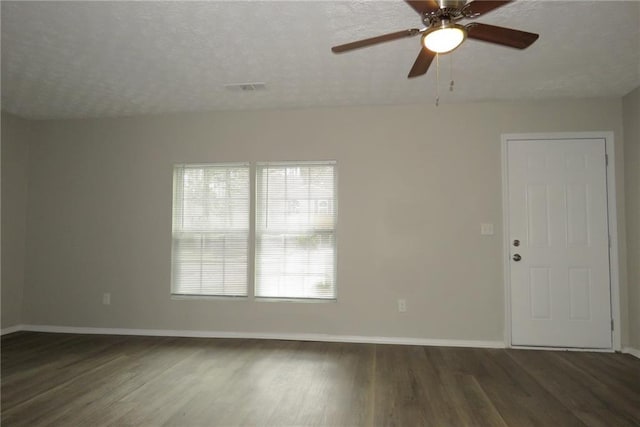 spare room featuring ceiling fan, dark hardwood / wood-style flooring, and a textured ceiling