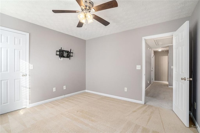 spare room featuring ceiling fan, light carpet, and a textured ceiling