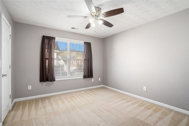 carpeted empty room featuring ceiling fan and a textured ceiling