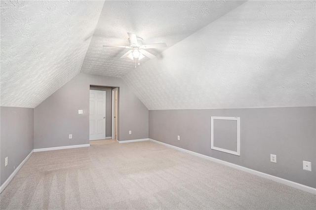 bonus room featuring ceiling fan, lofted ceiling, carpet, and a textured ceiling