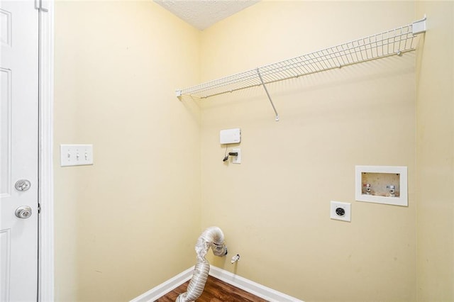 washroom featuring electric dryer hookup, dark wood-type flooring, washer hookup, and a textured ceiling