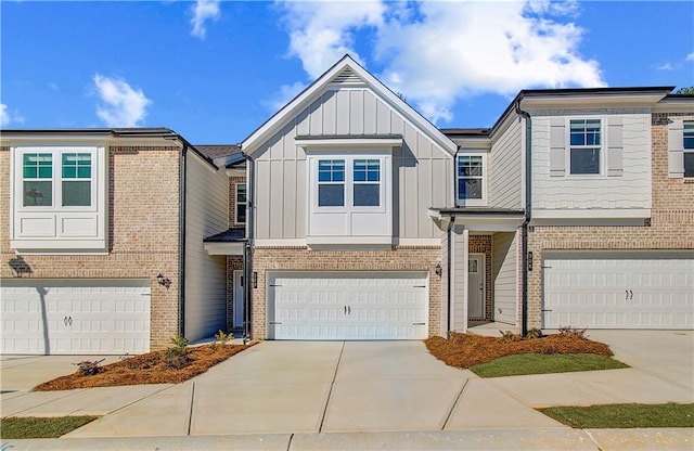 multi unit property featuring board and batten siding, concrete driveway, brick siding, and a garage