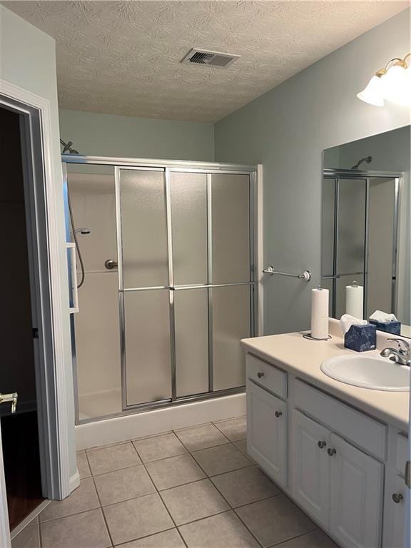 802 Village Pl, Loganville, GA 30052 - full bath with vanity, tile patterned floors, a shower stall, and a textured ceiling
