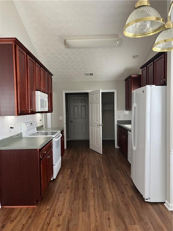 802 Village Pl, Loganville, GA 30052 - kitchen featuring white appliances, dark brown cabinets, dark wood finished floors, tasteful backsplash, and a textured ceiling