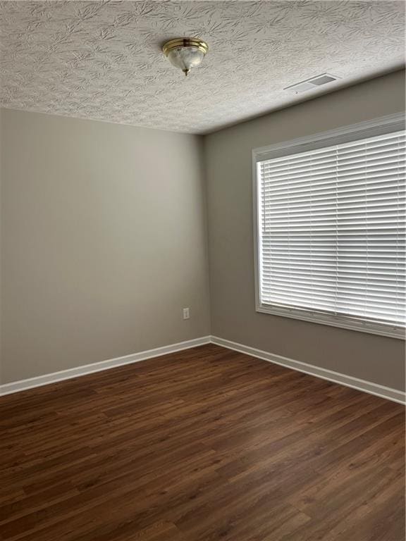 802 Village Pl, Loganville, GA 30052 - unfurnished room featuring baseboards, dark wood-style flooring, and a textured ceiling