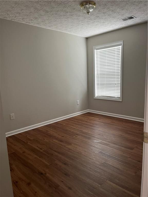 802 Village Pl, Loganville, GA 30052 - empty room with dark wood-style floors, baseboards, and a textured ceiling