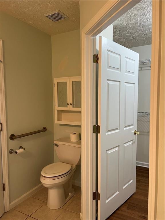 802 Village Pl, Loganville, GA 30052 - bathroom with toilet, baseboards, a textured ceiling, and tile patterned flooring