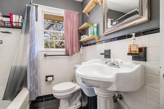 bathroom featuring tile patterned flooring, shower / tub combo with curtain, tile walls, and toilet