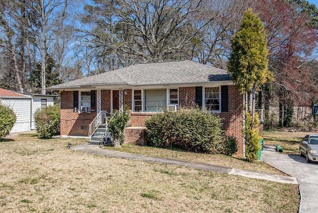 single story home featuring brick siding and a front yard