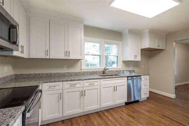 kitchen with white cabinets, appliances with stainless steel finishes, and light hardwood / wood-style floors