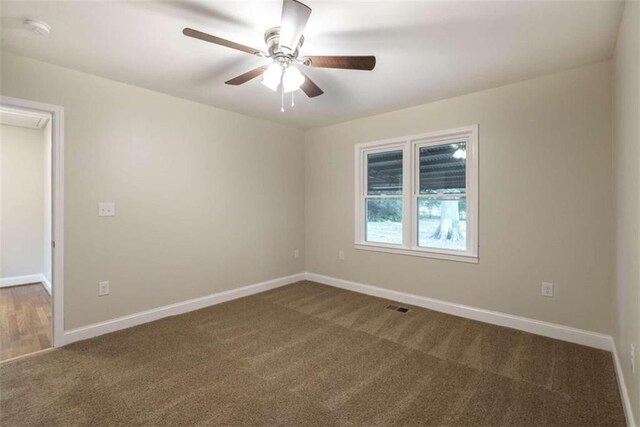 carpeted spare room featuring ceiling fan