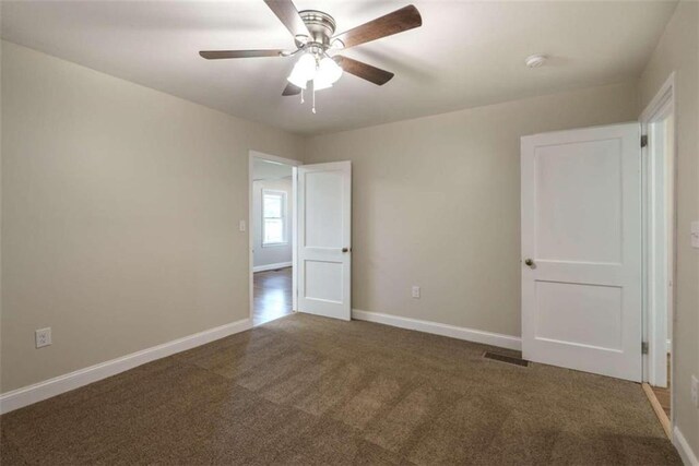 carpeted spare room with ceiling fan