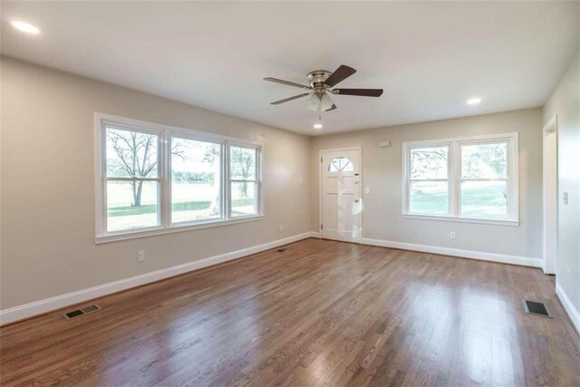 spare room with ceiling fan, hardwood / wood-style flooring, and plenty of natural light