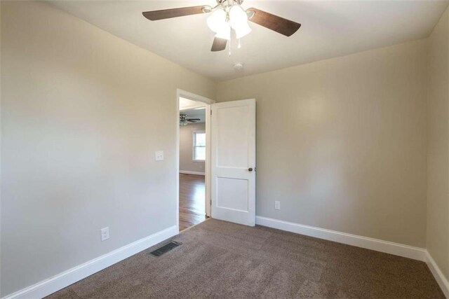 carpeted spare room with ceiling fan