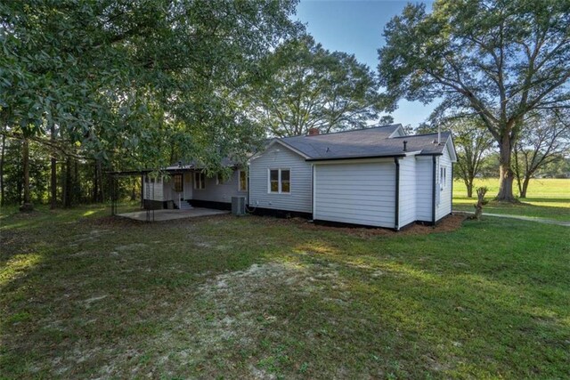 back of property with cooling unit, a yard, and a patio area