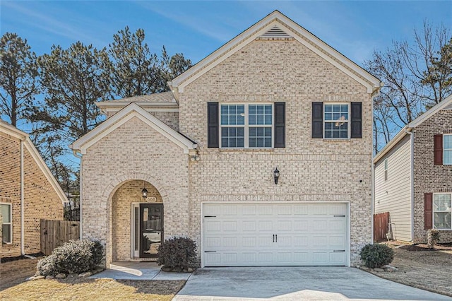 traditional-style home featuring a garage, fence, concrete driveway, and brick siding