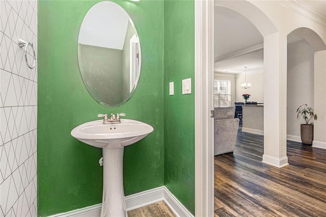 bathroom with baseboards, ornamental molding, and wood finished floors