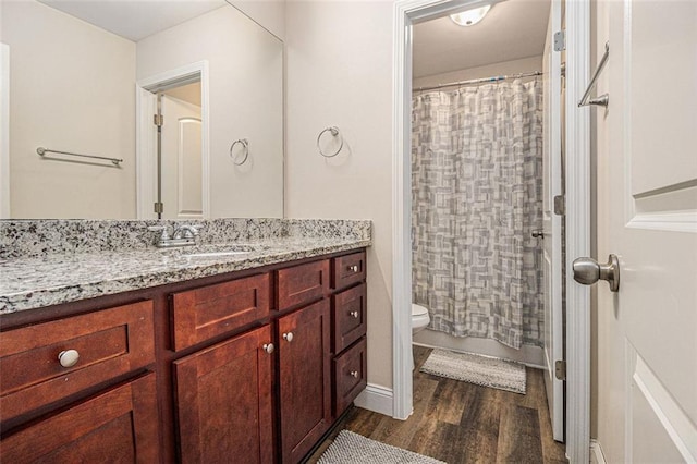 full bath with toilet, wood finished floors, and vanity