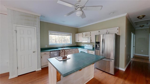 kitchen with sink, a center island, light hardwood / wood-style flooring, stainless steel appliances, and white cabinets