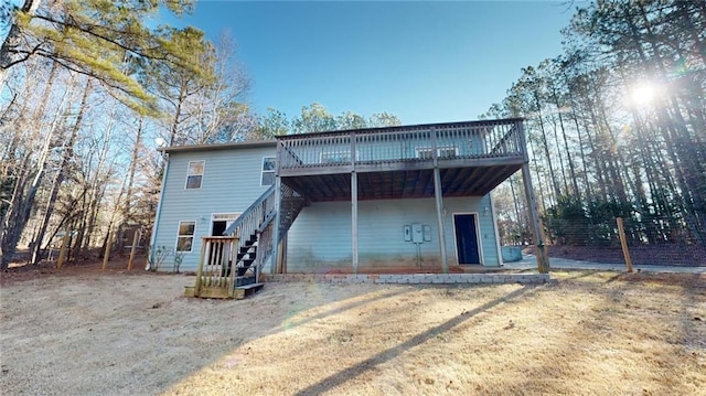 back of house featuring a wooden deck and a yard