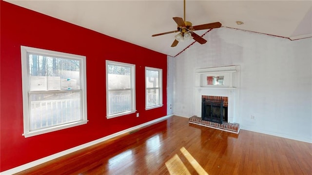 unfurnished living room with ceiling fan, wood-type flooring, a fireplace, and vaulted ceiling