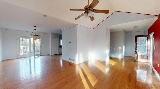 unfurnished room with crown molding, vaulted ceiling, ceiling fan, and light wood-type flooring