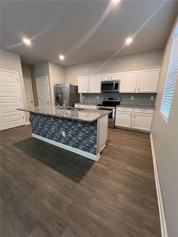 unfurnished living room with ceiling fan and wood-type flooring